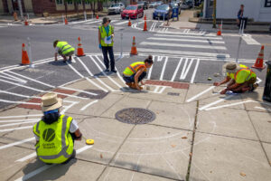 Highlandtown Park Shine perspective of Graham Projects artists masking artwork on sidewalk
