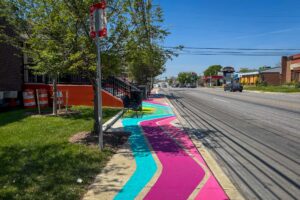 Reisterstown Rd Library Glen Flows art crosswalk and sidewalk mural perspective view of sidewalk and bus stop