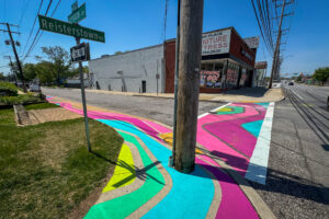 Reisterstown Rd Library Glen Flows art crosswalk and sidewalk mural perspective view of street corner and crosswalk
