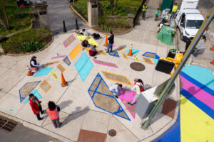 Patterson Plumage community paint day birds eye view with residents painting the sidewalk entrance to Patterson Park