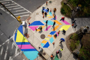 Patterson Plumage community paint day birds eye view of large, colorful abstract bird track at entrance to Patterson Park