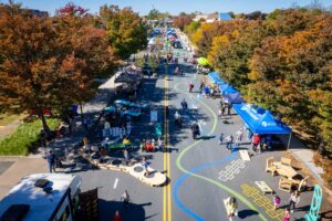 Damascus Placemaking Festival birds eye view facing west with blue and green curvilinear wayfinding spray chalk pavement art and street games in the foreground with lots of pedestrians walking around
