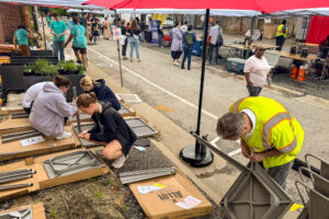 Lortz Lane LortzWave shared street pavement art community members assembling tables and chairs