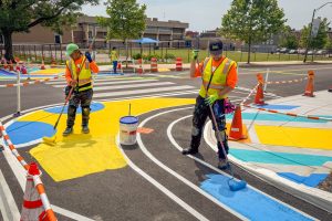 Franklin Square EMS Heraldic Bands installation perspective of Melvin and Jonathan painting the pavement