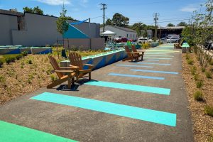2700 Art Space waveform promenade mural with adirondack chairs and sittable concrete blocks