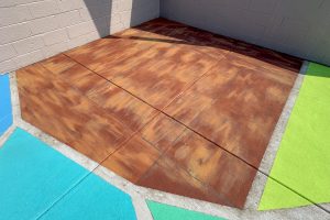 2700 Art Space ministage concrete floor with faux wood pavement art evoking the unique trapezoidal shape of the original drum riser