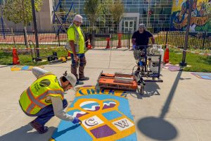 Chick Webb Recreation Center pavement art installation Shawn operating infrared heater with Mar taking temperature and Liam testing adherence
